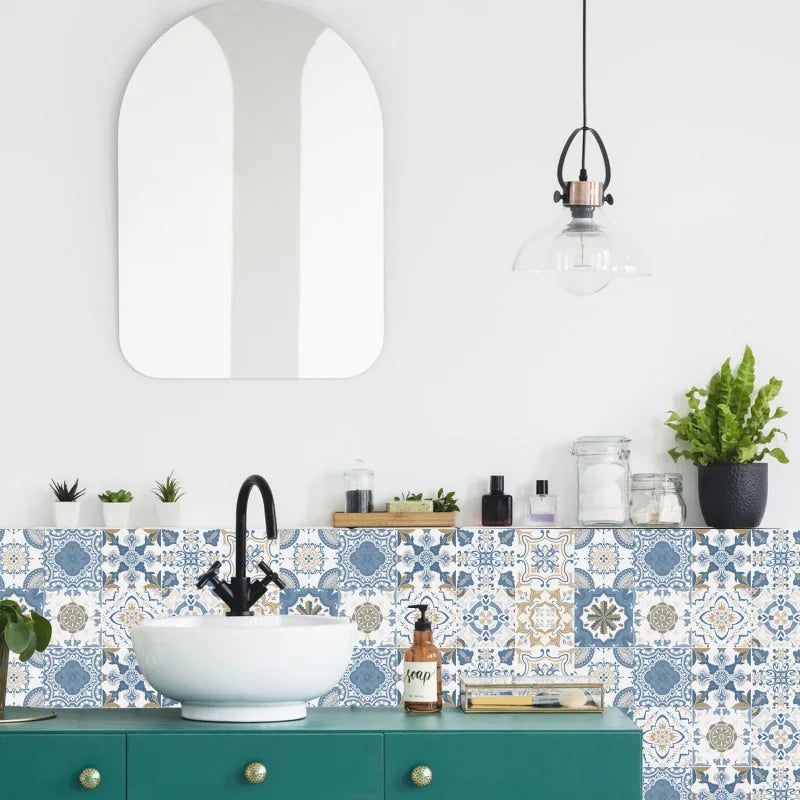 Blue and white patterned tile stickers behind a white vessel basin on a green bathroom vanity